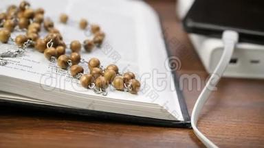 从电源库充电，打开神圣圣经与珠子交叉在棕色木桌